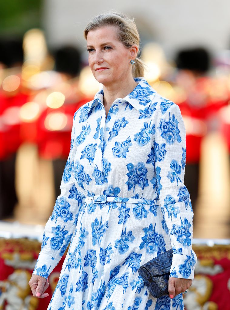 Sophie, Duchess of Edinburgh looks to left in blue and white floral dress