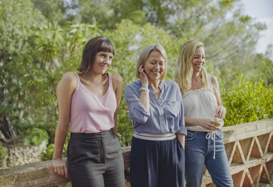 Three sisters standing on a bridge.
