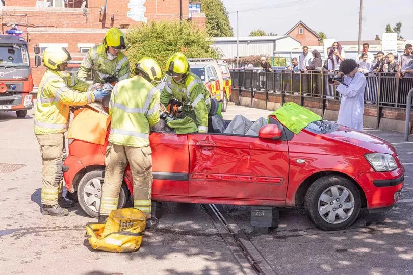 The recovery of a road traffic accident victim is reconstructed in Morrisons car park by Green Lane Mosque in front of a crowd. This is being done in order to deter people from driving over the speed limit or under the influence of nitrous oxide, drugs or alcohol. -Credit:Birmingham Live