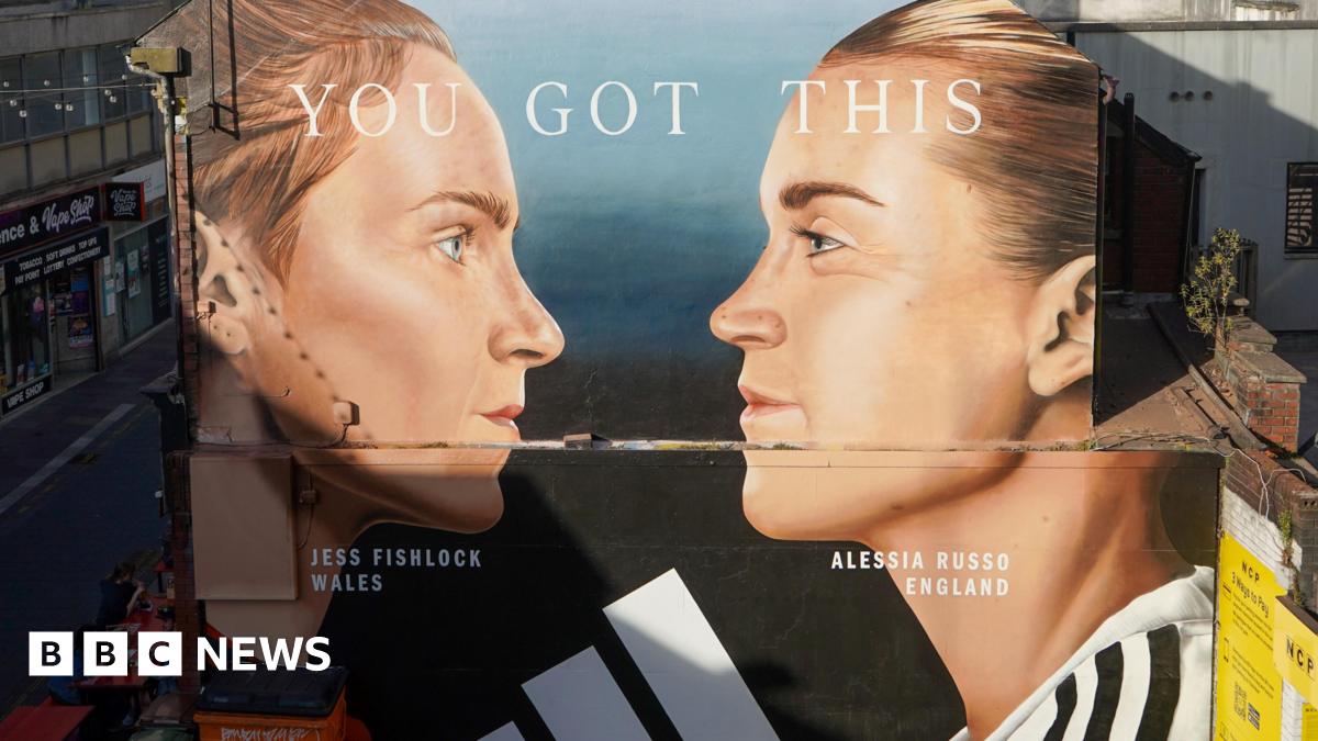 A mural painting on a side of the wall featuring the two football players, Jessica Fishlock and Alessia Russo. It shows their faces in profile, facing each other. Their hair is tied back and their football shirts are just visible at the bottom of the mural.
