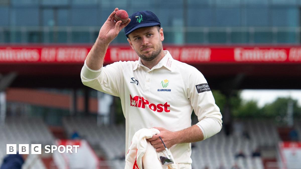 Mason Crance holds a cricket ball to acknowledge fans at the Old Trafford cricket ground