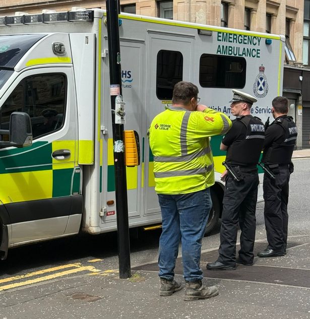 Police stand guard outside an ambulance