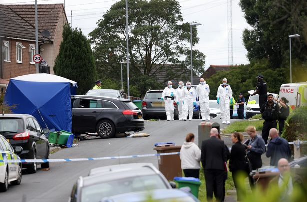 Residents look on as police carry out their work on Rowrah Crescent 