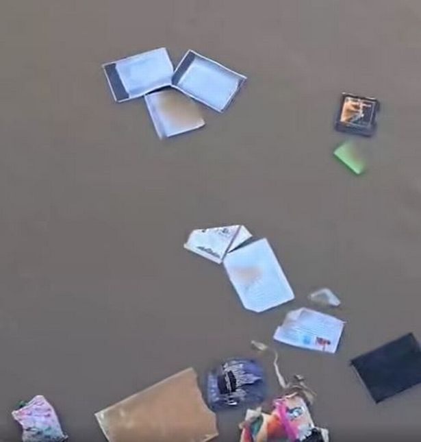 The image shows bits of paper, cardboard and cards in the river
