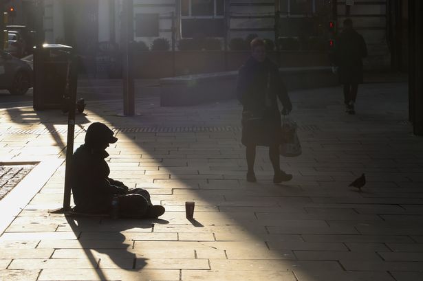 A homeless man sits on the street in Liverpool city centre