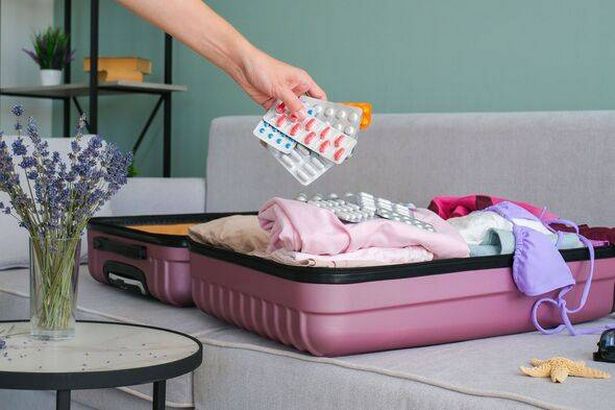 A woman puts pills in a suitcase. Concept of medication required in journey