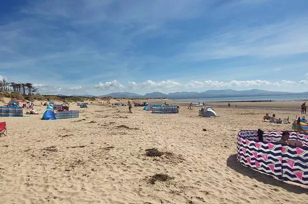 Traeth Llanddwyn beach bordered by Newborough Forest with dramatic views across to Eryri