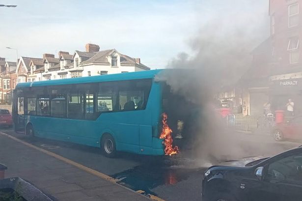 Smoke billows from the rear engine of an Arriva bus on Rake Lane, Wallasey