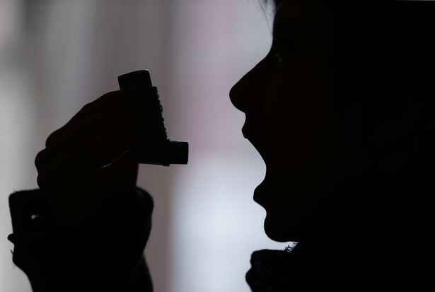 a person using an inhaler for the treatment of asthma