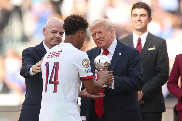 Desire Doue of Paris Saint-Germain is handed his FIFA Best Young Player award from U.S. President Donald Trump 