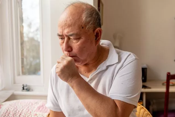 A elderly man coughing.