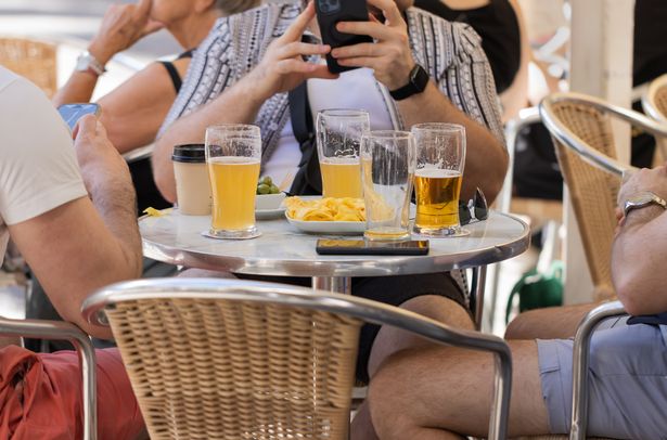 Unrecognizable friends sit together at a table at a beer party