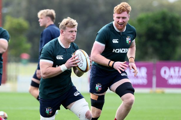 British and Irish Lions' player Jac Morgan runs with the ball next to teammate Ollie Chessum (R)