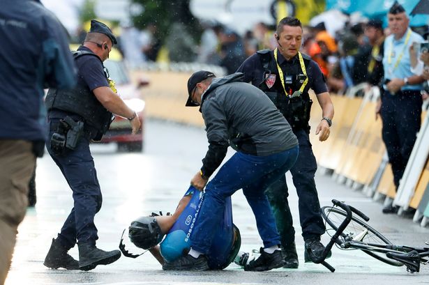 VALENCE, FRANCE - JULY 23: An amateur cyclist trying to cross the finish line few minutes before the pack is pushed down by a cop and arrested during Stage 17 of the 112th Tour de France 2025, a 160.4 km stage from Bollene to  Valence on July 23, 2025 in Valence, France. (Photo by Jean Catuffe/Getty Images)