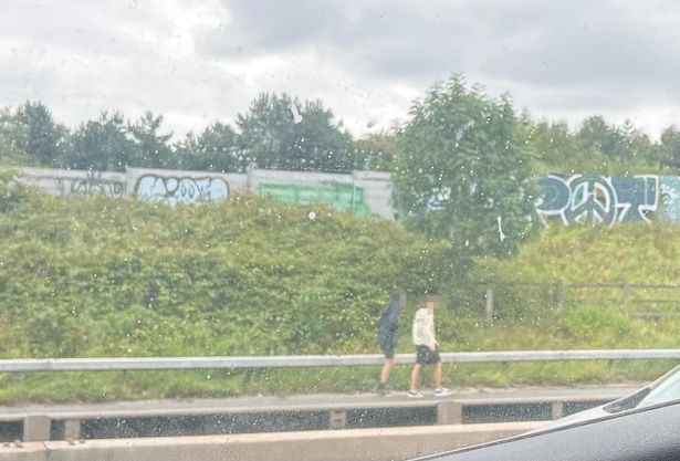 Pedestrians ditch cars and walk along M60 