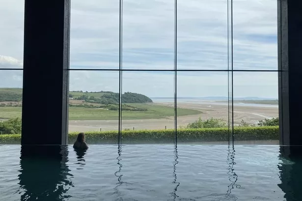 Woman looking out of the window while in the swimming pool at Dylan Coastal Resort Laugharne
