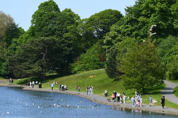 People enjoying a walk around the lake in Sefton Park