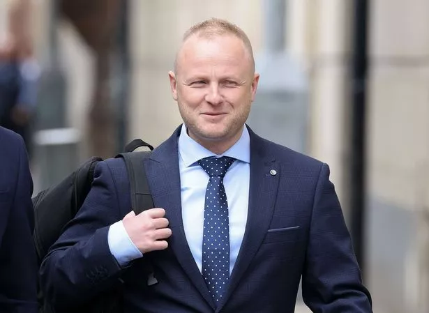 Jamie Bryson arriving at Laganside Courts in Belfast last month in navy suit and tie 