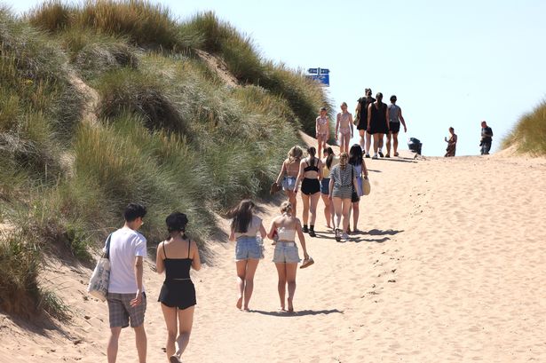 Crowds walk to Crosby beach to enjoy the hot weather