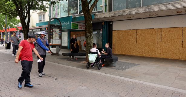The image shows further boarded up shops