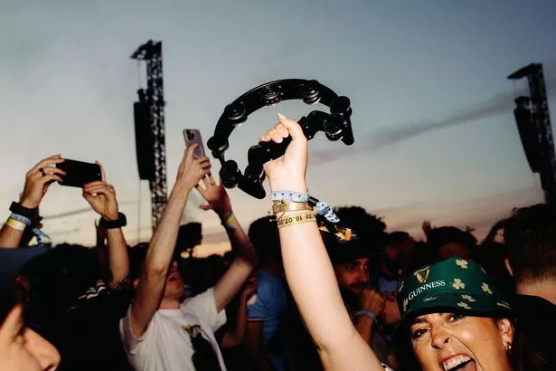 Oasis fans carrying musical instruments to match the band