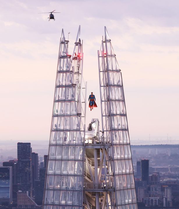 Superman soars above London in a spectacular display at the highest point of The Shard, as Daily Planet helicopters circle ​the skyscraper at first light.