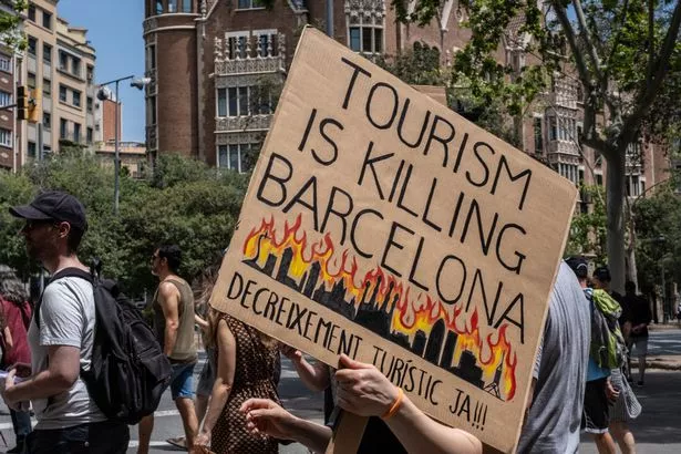Protestors march during an anti-tourism protest on June 15, 2025 in Barcelona, Spain