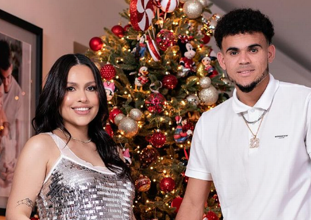 Luis Diaz and his partner Gera Ponce standing in front of a Christmas tree