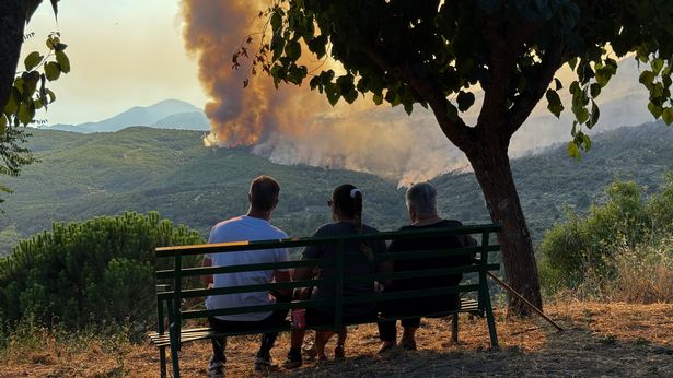  People are seen as a wildfire breaks out during scorching temperatures in Avila, Spain