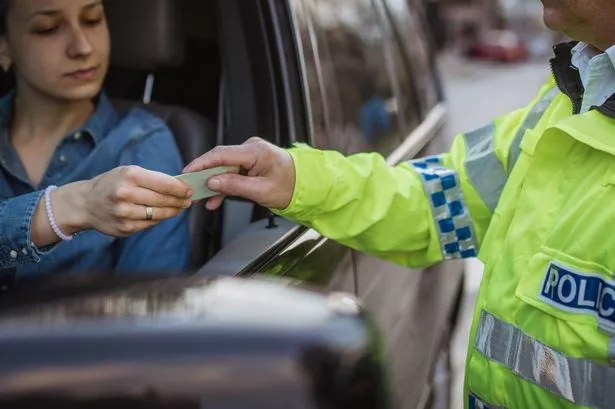 Man and woman, police officer making a traffic stop on the street.