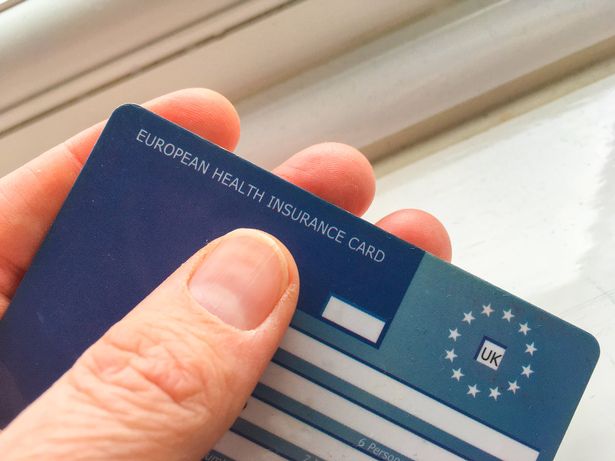 Close up of a UK European Health Insurance Card being held in a hand