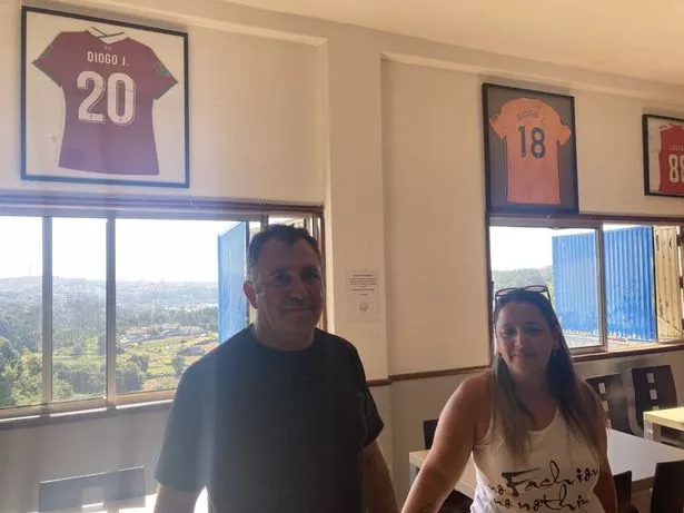Carlos Sousa and Vanessa Marques in front of the two shirts Diogo Jota donated to their pub