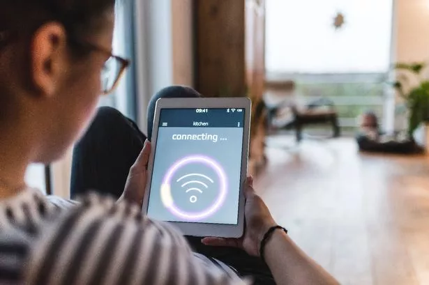 A woman looking at her tablet and checking her Wi-Fi connection