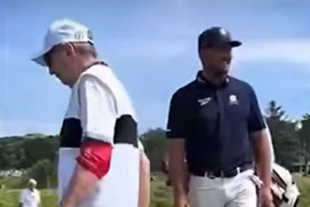 An Open spotter walks away after being told to move by Bryson DeChambeau