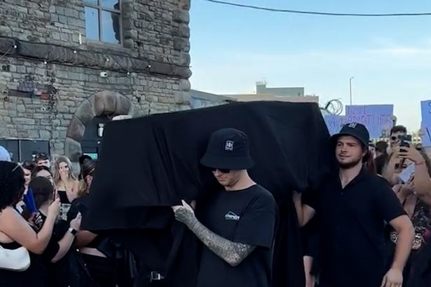 Mourners turned up to throw flowers on a coffin