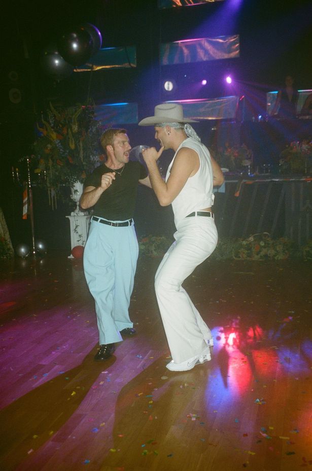 An outfit change to a powder blue suit and a white suit to get the party started.
