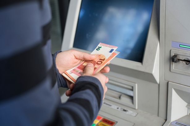 Person withdrawing Euros from a cash machine