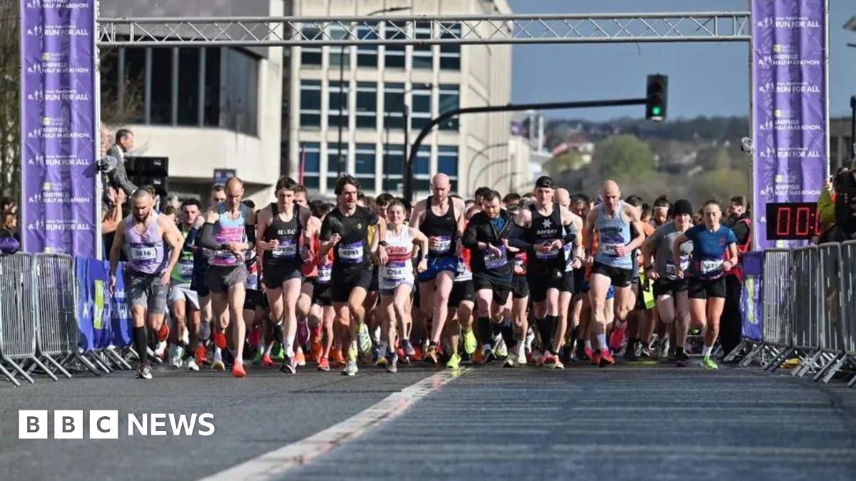 A large group of runners at the start line of the Sheffield Half Marathon in 2024. They are mostly men in shorts and vests. It is a sunny day.