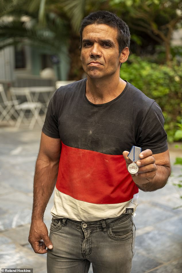 Francisco Garcia claims to have been one of hundreds on a flight from Havana to Moscow after answering an advertisement looking for builders to repair sites damaged by Ukrainian bombardment. Pictured: Francisco brandishing a medal awarded by the Russian army