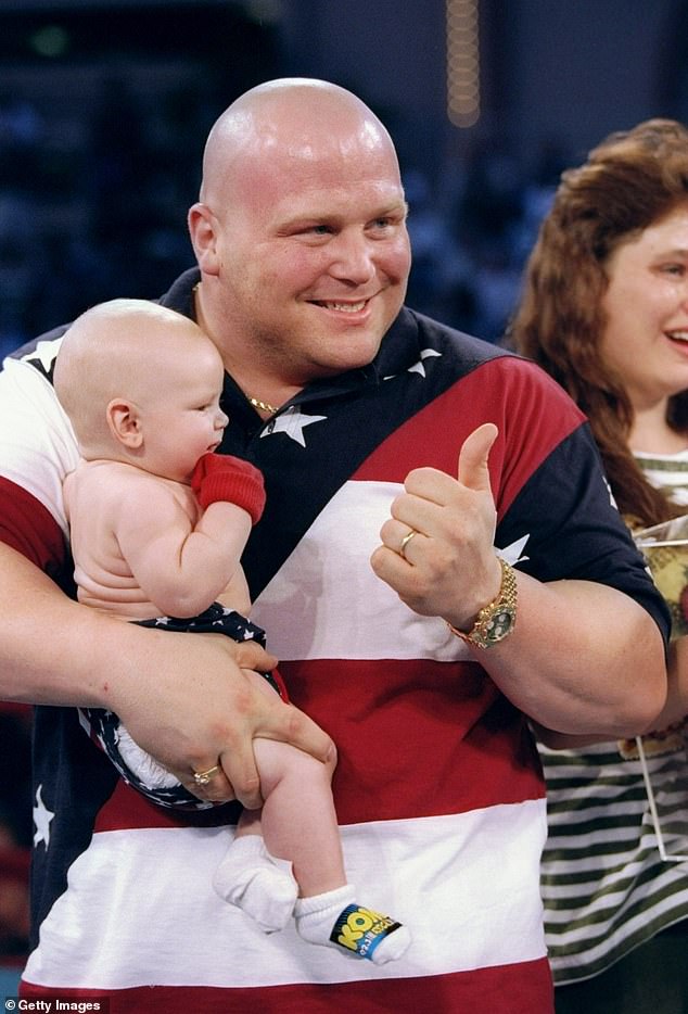 Butterbean holds a baby during a Butterbean Lookalike Contest in Las Vegas