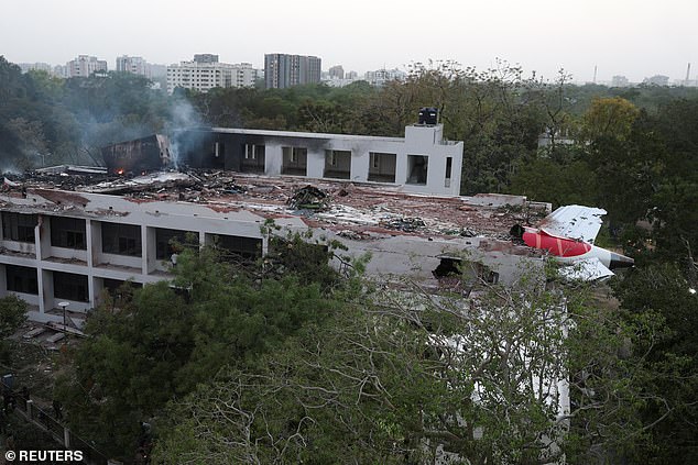 Pictured: The Air India flight 171 stuck on the side of the building after the crash