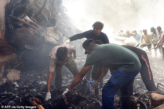 Pictured: Rescue workers at the site of the crash. The repatriation of Britons killed in the Air India disaster has been horrifically bungled, the Daily Mail can reveal
