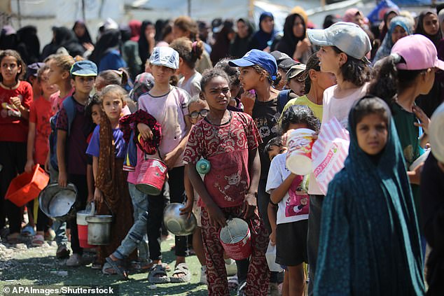 Palestinians gather in a charity kitchen to receive limited rations amid a shortage of food in Nuseirat refugee camp in the centre of the Gaza Strip