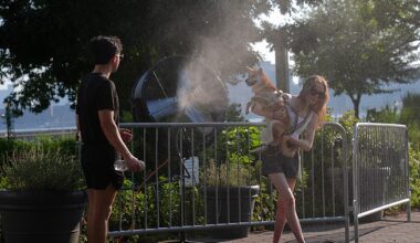 New Yorkers try to cool off with a fan that sprays water during a hot day as the National Weather Service on Monday issued a warning due to extremely high temperatures