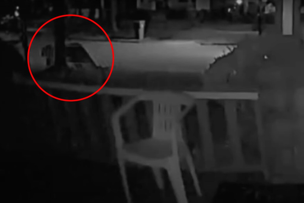 Nighttime security camera footage of a car and overturned chair.