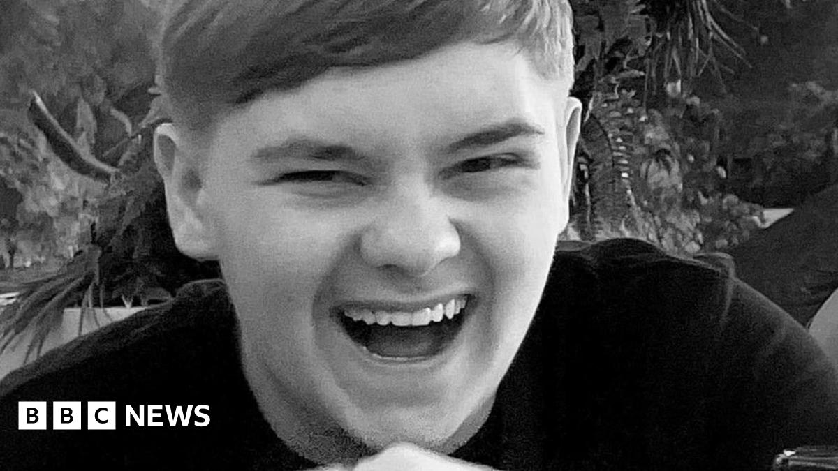 Black and white close-up of Harvey Willgoose, laughing and looking at the camera