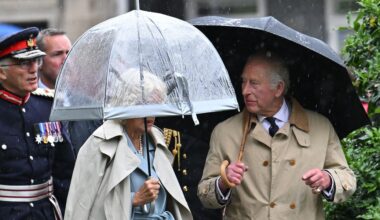 Queen Camilla's face shielded from view as she joins King Charles with huge umbrella