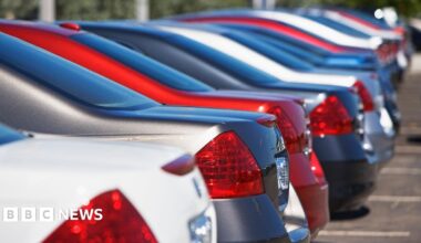A row of cars sit in a car park in a car park.