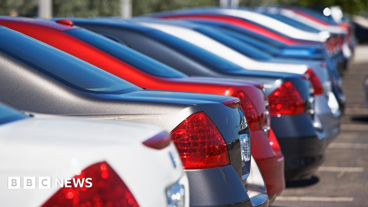 A row of cars sit in a car park in a car park.