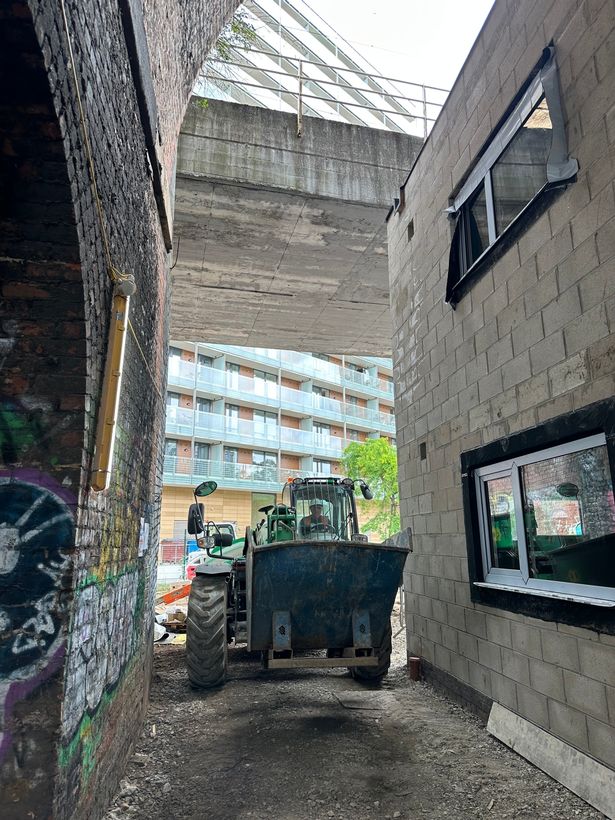 Diggers and machinery make their way between graffitied walls and the new builds. 